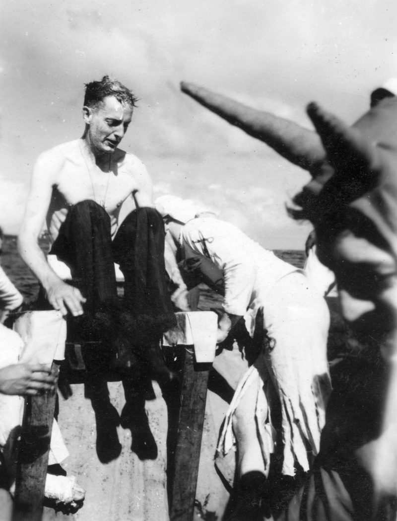 Lt Cdr Dornin about to be dunked.<br>E. Johnston (devil) looks on; 25DEC1943.