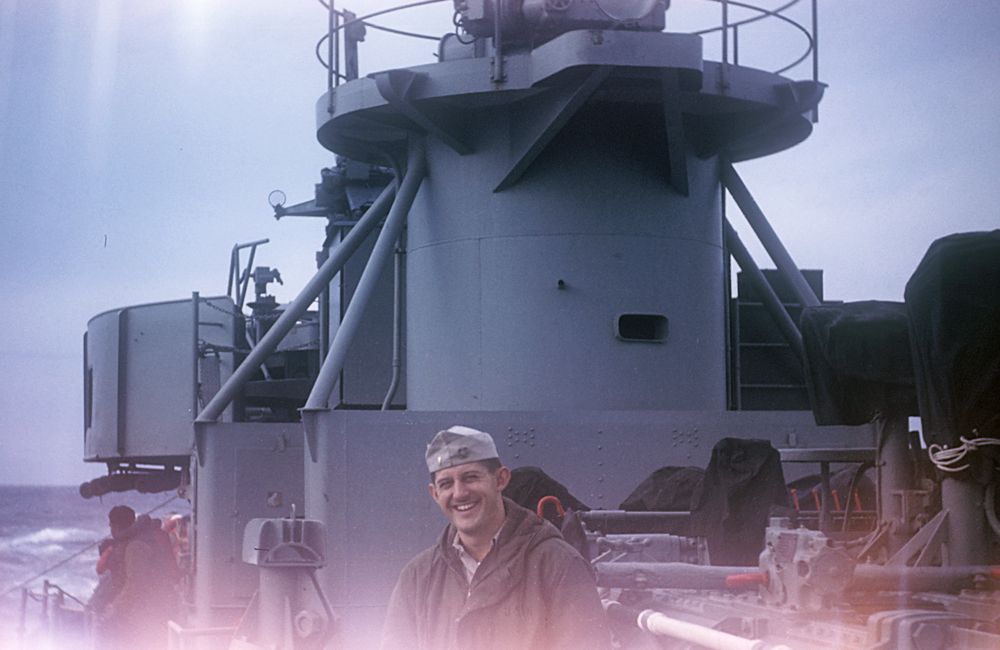 Lt. (j.g.) Edmund B. Bossart Jr. near torpedo tubes